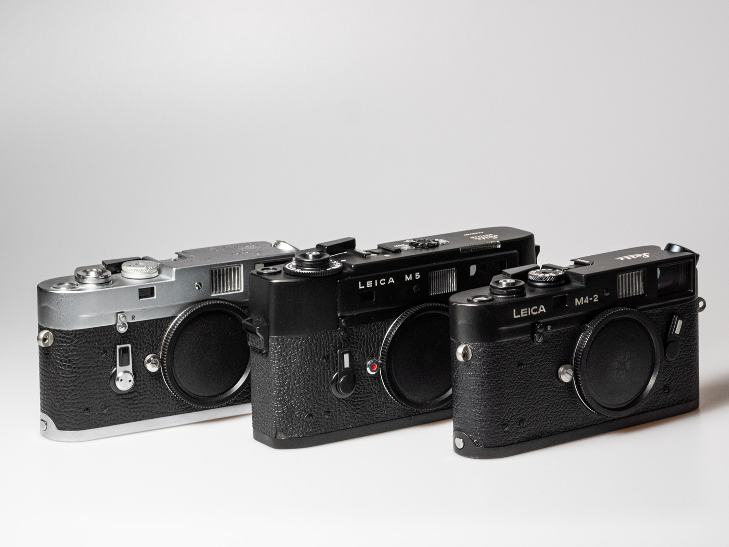 Produktfoto zeigt Leica M5, analoge Messsucherkamera (1971-1975), mit Vorgängermodell M4 und Nachfolgemodell M4-2