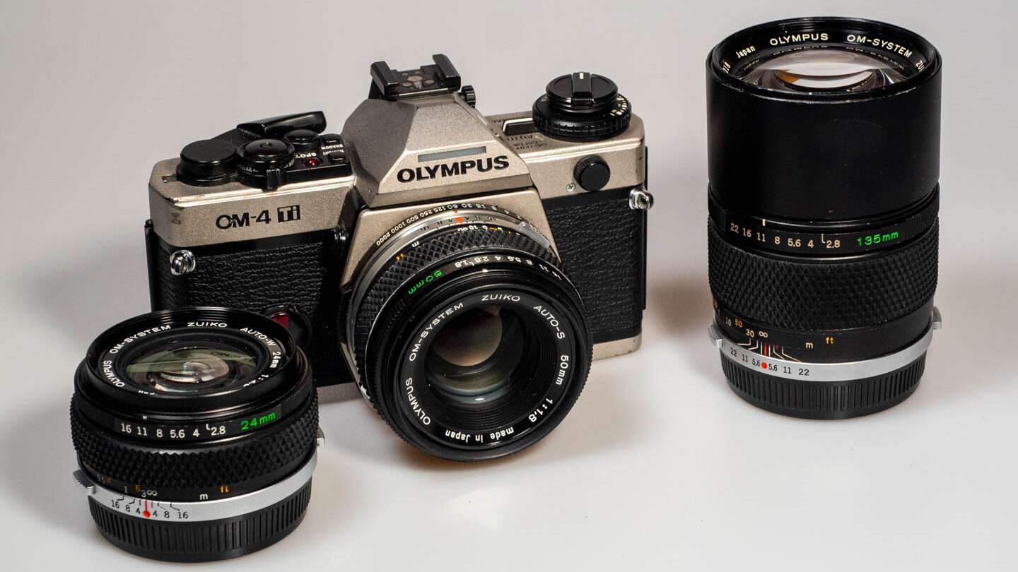 Produktfoto zeigt OM System Olympus OM-4 Ti, mit Objektiven